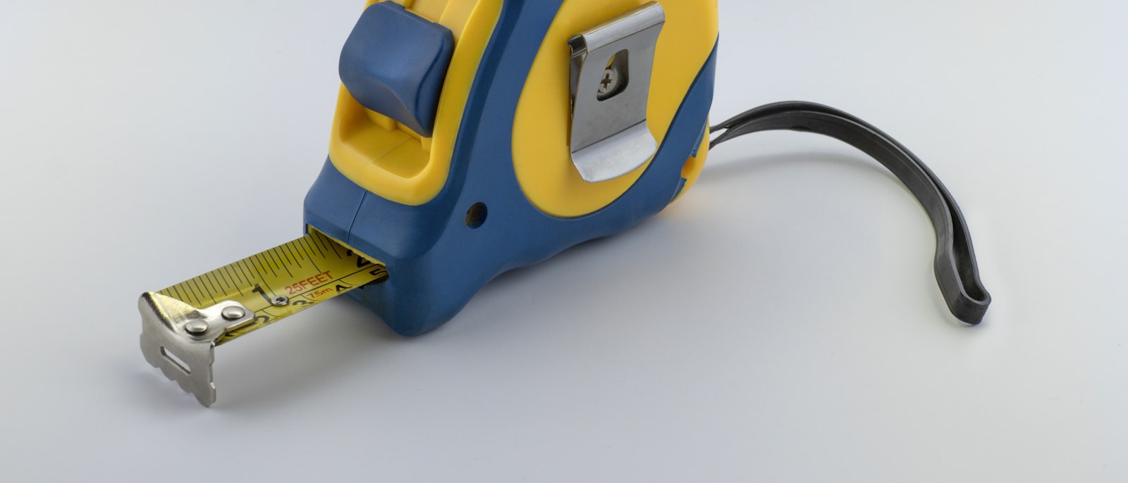 A blue and yellow measuring tape on a workbench