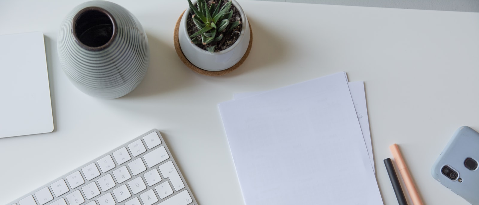 white printer paper beside white apple keyboard